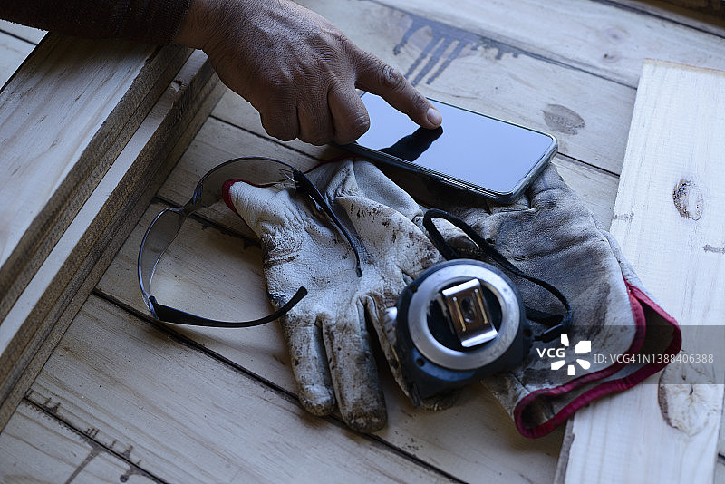 木匠使用智能手机购买材料图片素材