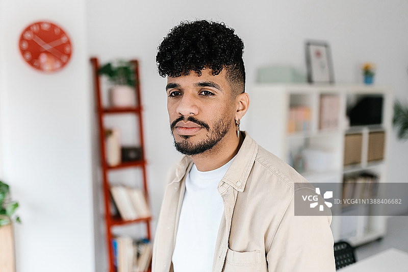 在家中室内面无表情地看向远方的年轻拉丁美洲男子图片素材