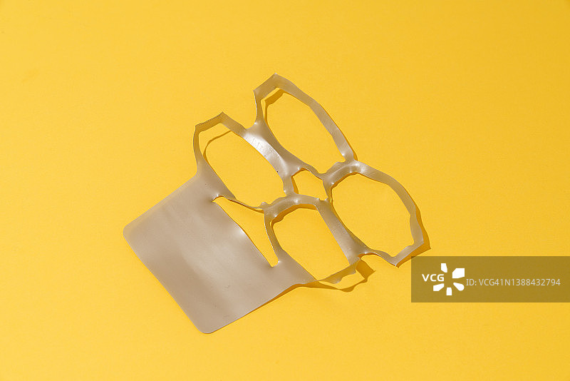 黄色背景上的塑料环 - 六罐装提环图片素材