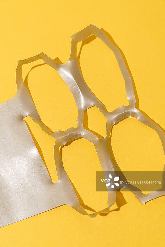 黄色背景上的塑料环 - 六罐装提环图片素材