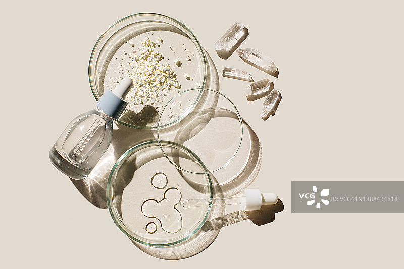 米色背景上的美容产品样品培养皿和化妆品玻璃瓶。化妆品实验室研究概念。皮肤科学。天然药物、化妆品研究、有机美容产品（俯视图，平铺，留白）图片素材