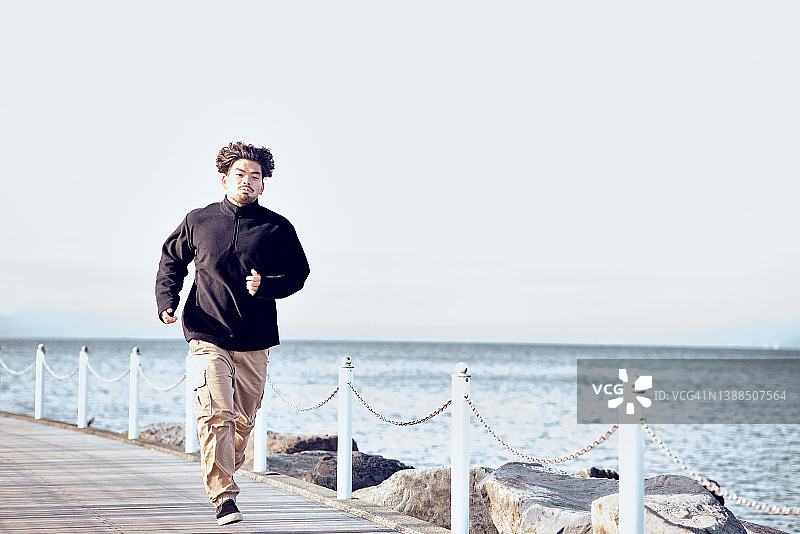 年轻人在防波堤上跑步图片素材