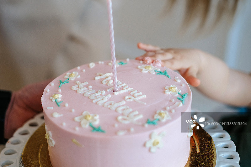 为小女孩准备的生日蛋糕照片，1岁生日，一只小手伸向蛋糕图片素材
