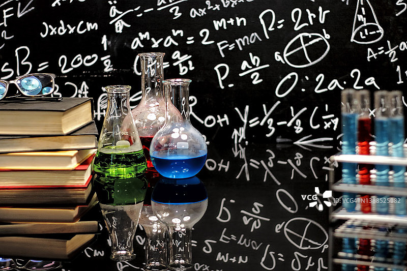 带有书籍和仪器化学教学的教室桌子和手绘黑板。化学科学教育概念。图片素材