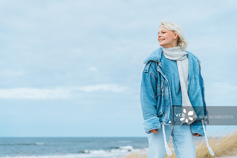 在海边独自散步的年轻金发少女图片素材