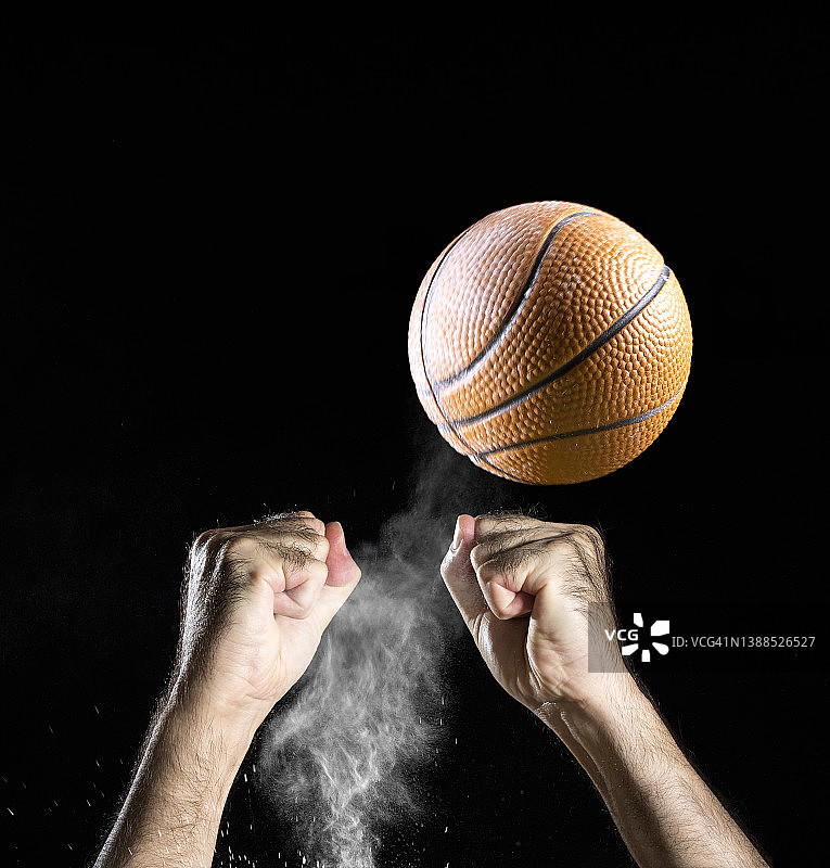 篮球运动员在黑色背景上接球的手图片素材