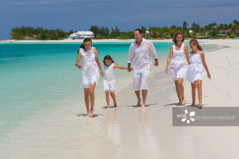 快乐的白人家庭在白色沙滩上散步图片素材
