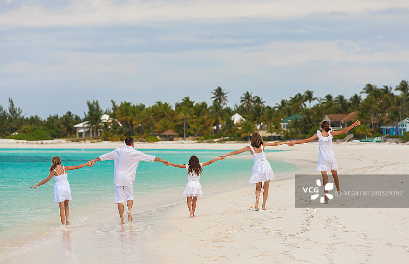 年轻的白人父母和孩子在海滩上玩耍图片素材