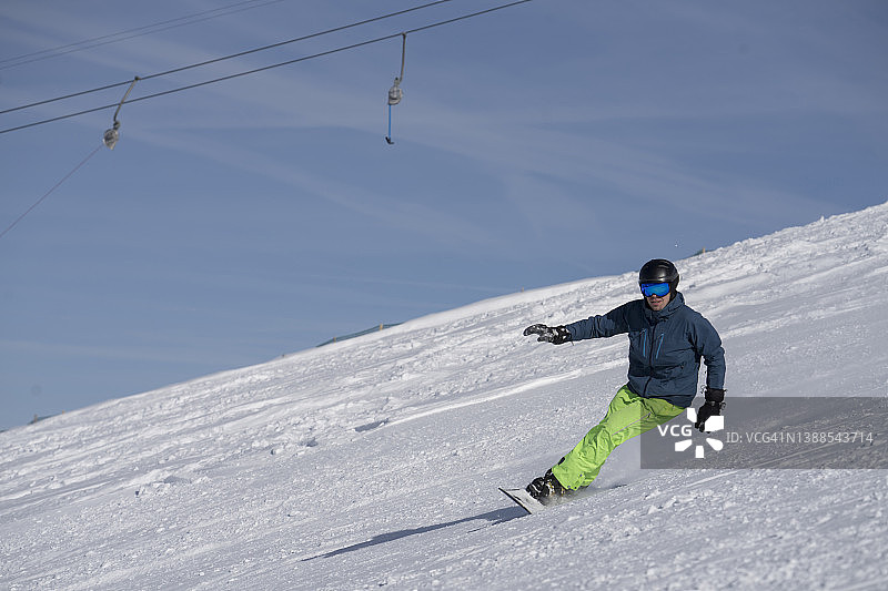 男人在滑雪板上滑下雪坡图片素材