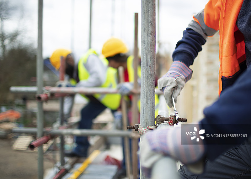 建筑工人在建筑工地组装脚手架图片素材
