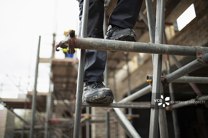 建筑工人在建筑工地攀爬脚手架图片素材