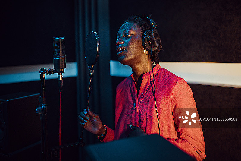 在音乐工作室唱歌和录音的黑人女性图片素材