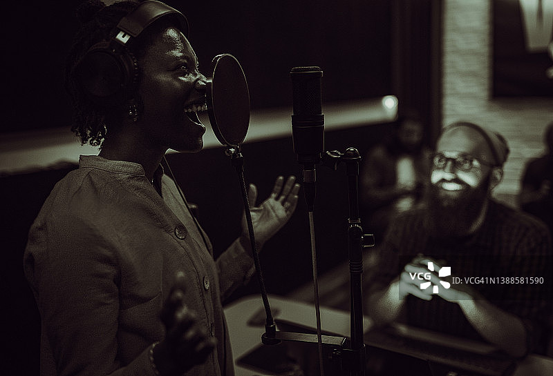 在音乐工作室唱歌和录音的黑人女性图片素材