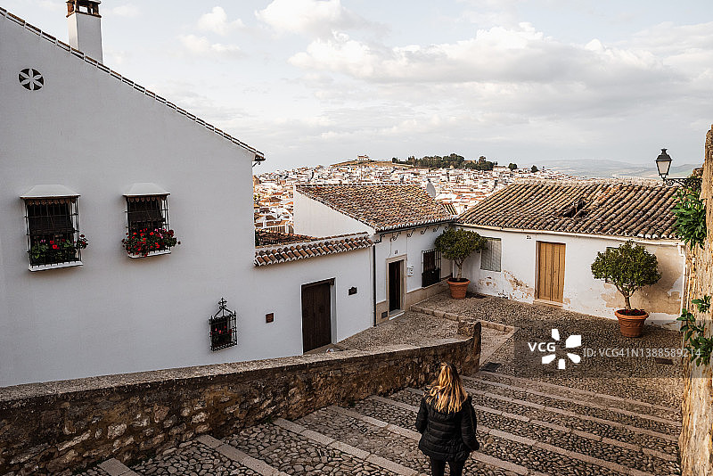 年轻女人在安达卢西亚村庄观光下楼梯图片素材