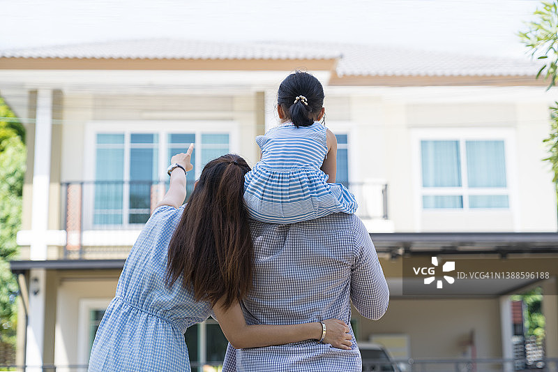 幸福家庭搬进新家欣赏房屋的背影图片素材