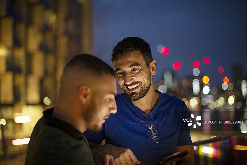 夜晚在城市里使用智能手机的快乐男士图片素材