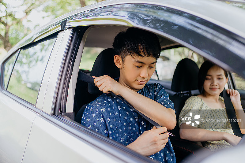亚洲情侣在车内系安全带图片素材