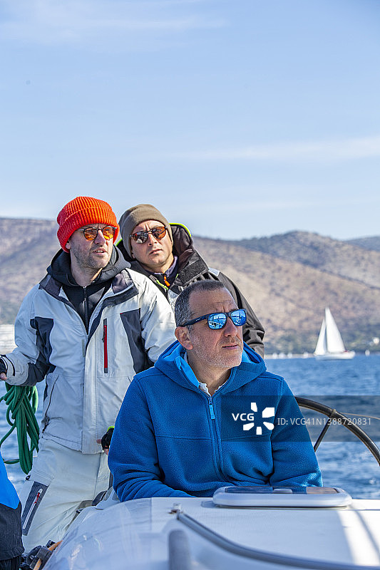 三名水手专注目标，赢得帆船赛图片素材