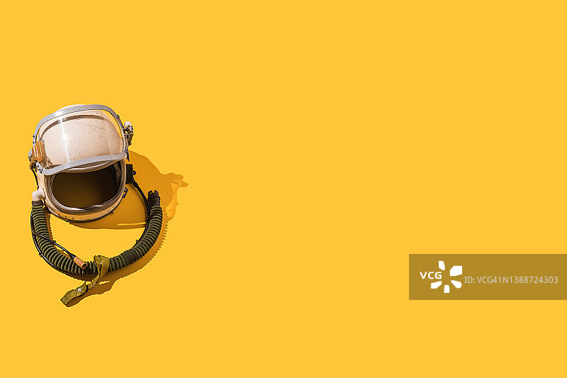 黄色背景上的复古乌克兰宇航员头盔。飞行、驾驶、太空、探索和幻想概念。图片素材