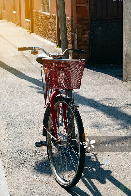 阳光明媚的夏日，格鲁吉亚街头，靠在柱子上的带篮子复古自行车图片素材