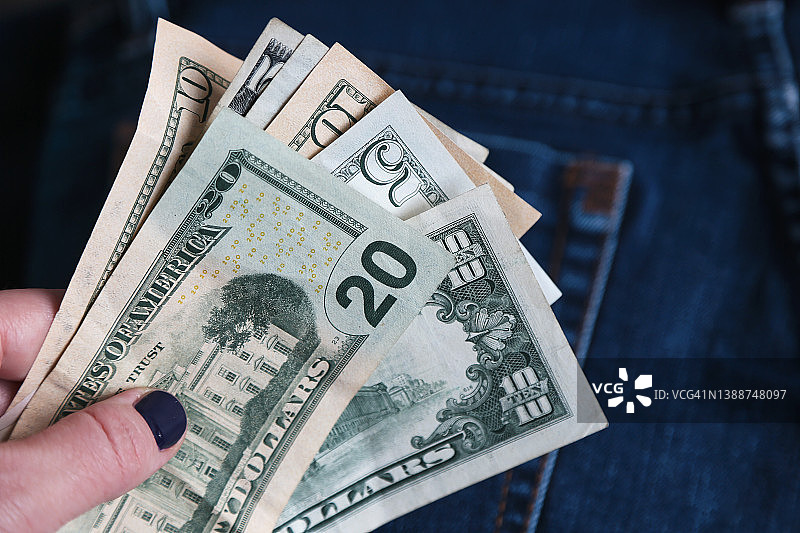 蓝色牛仔背景上的美元纸币图片素材