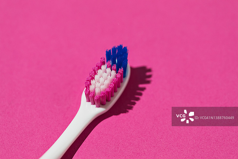 粉色背景蓝色粉色刷毛白色牙刷细节，口腔卫生牙齿牙医龋齿概念图片素材