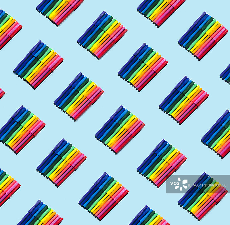 蓝色粉彩背景上不同颜色的学校记号笔套装无缝图案图片素材