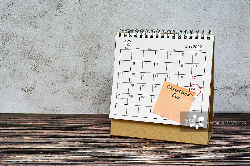 木桌上的2022年12月日历，带有日期圈和便签上的文本图片素材