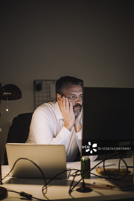 有抱负的商人在工作场所争分夺秒地使用电脑图片素材