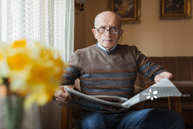 年长的男人手里拿着报纸图片素材