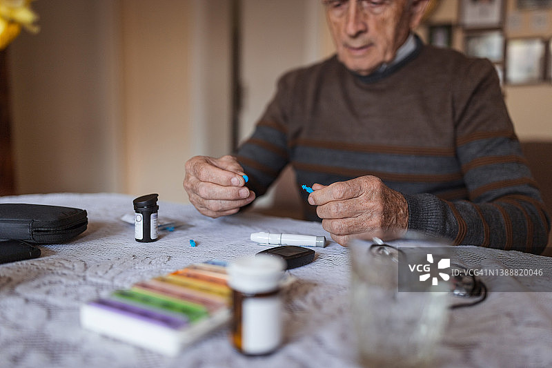 年长的男人在家检测血糖图片素材