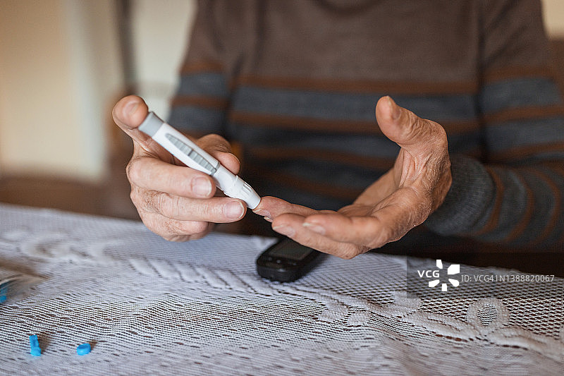 老年男子用血糖仪检查血糖水平图片素材