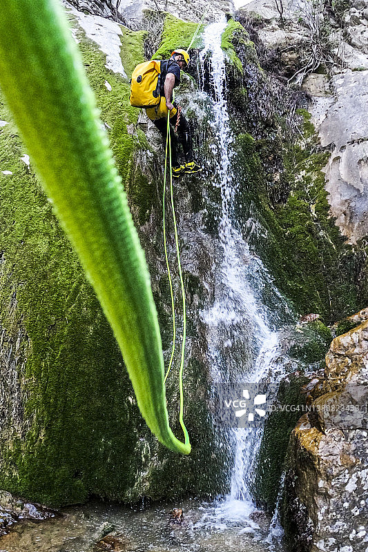 极限峡谷漂流队成员使用绿色绳索速降图片素材