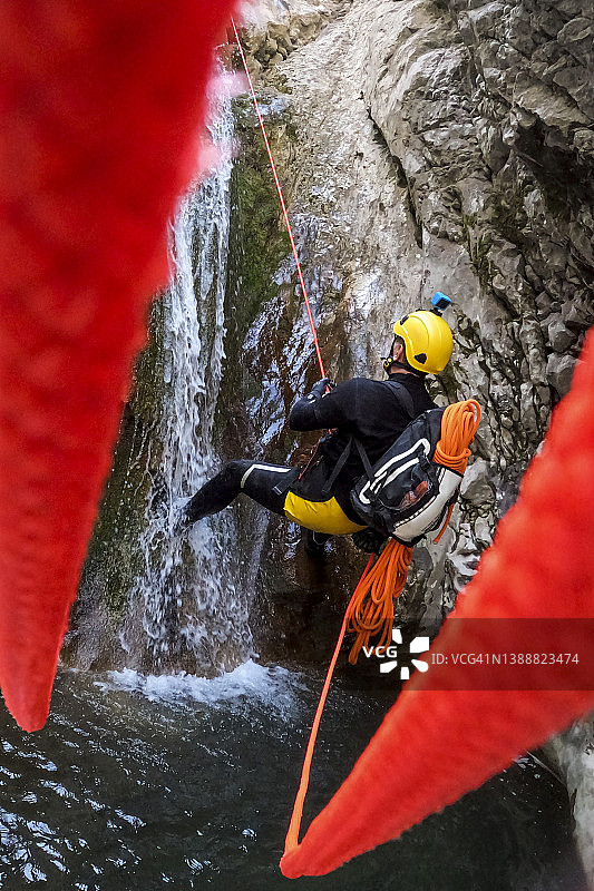 峡谷漂流队员使用橙色绳索速降图片素材