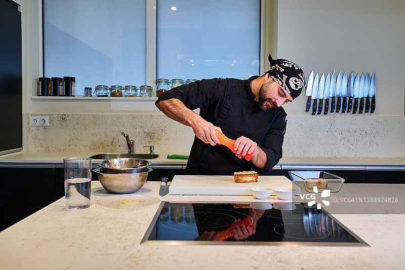 厨师在现代厨房的香蕉泥吐司上撒胡椒粉图片素材