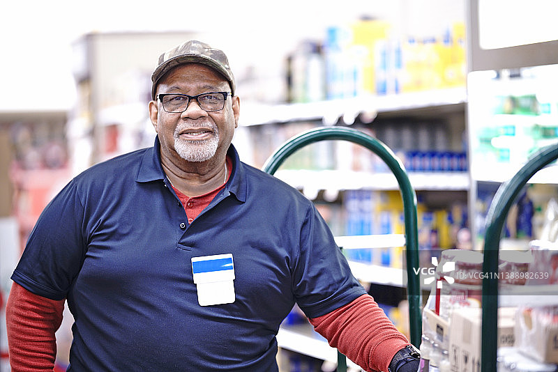 一个在杂货店工作的老年男子的肖像-库存照片图片素材