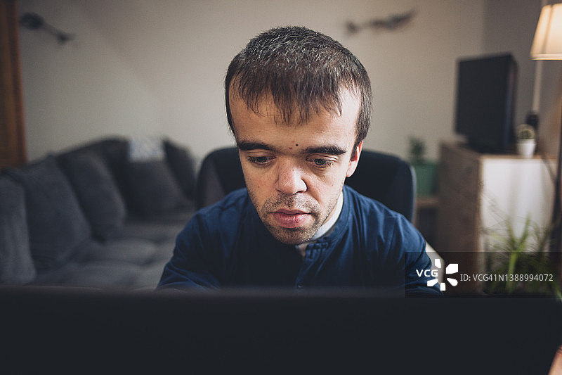 在家工作的患有侏儒症的年轻男人图片素材