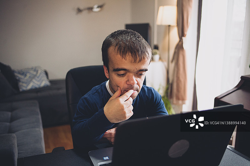 在家工作的患有侏儒症的年轻男人图片素材