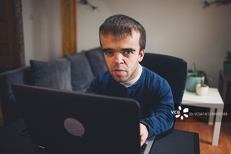 在家工作的患有侏儒症的年轻男人图片素材