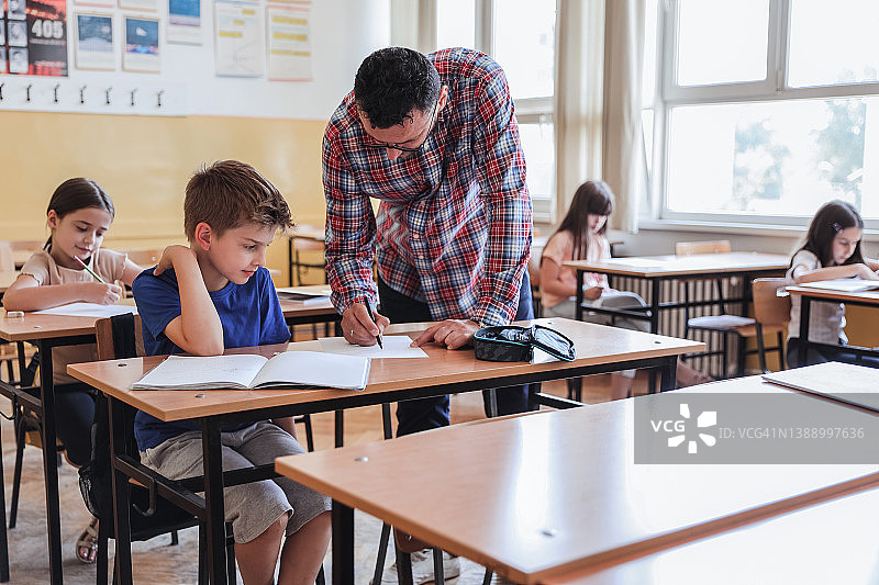 男孩专心听老师辅导功课图片素材