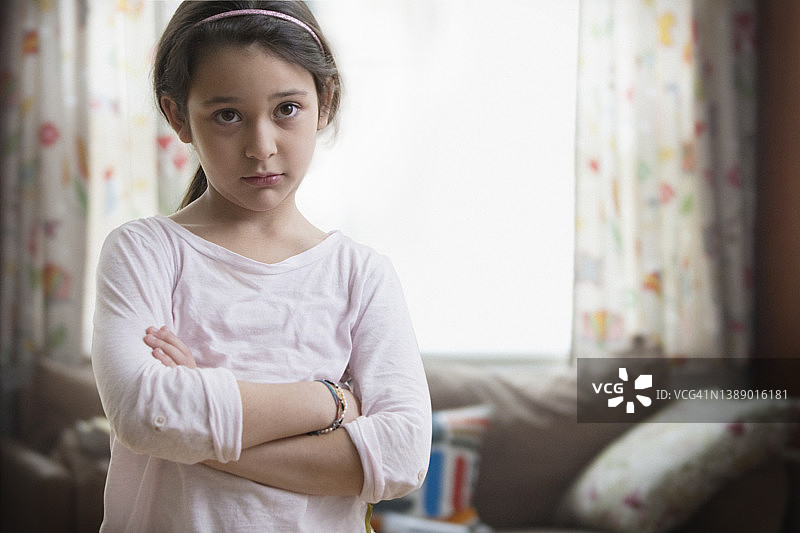 小女孩在客厅里皱着眉头图片素材