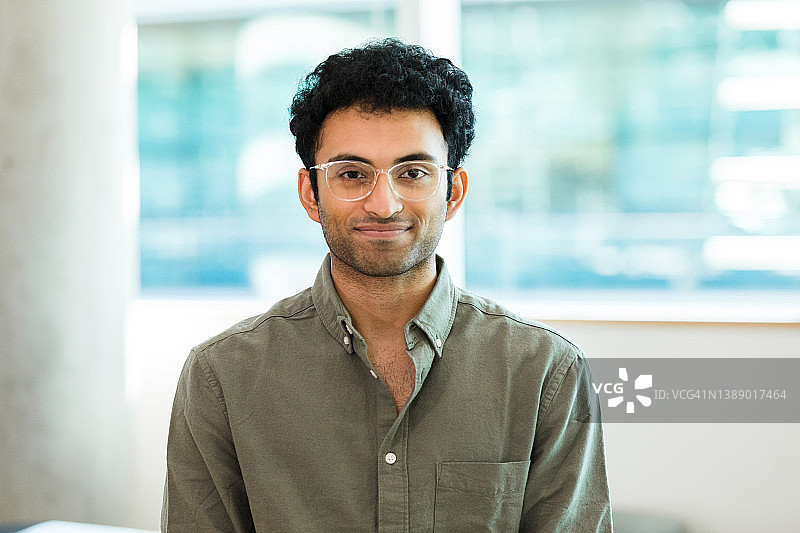 穿着纽扣衬衫和眼镜摆姿势拍照的男人图片素材