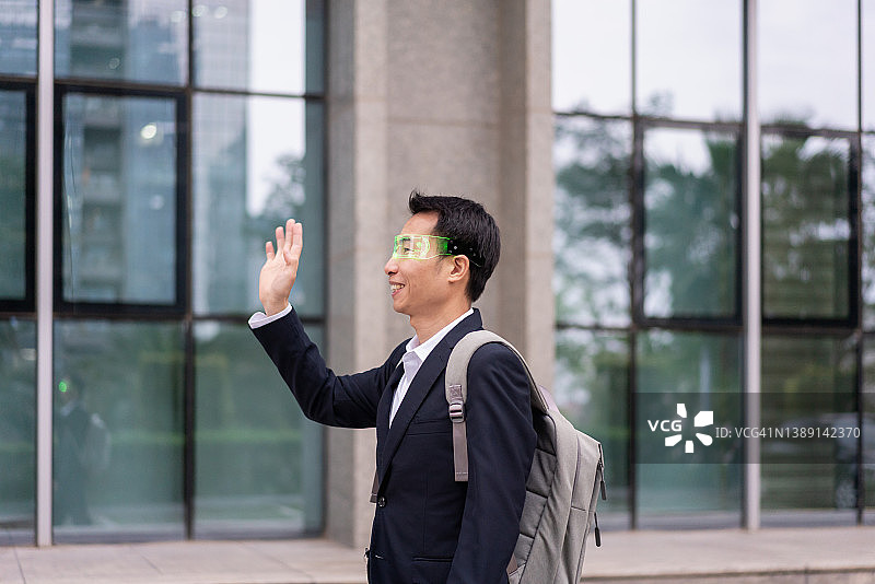 使用智能眼镜行走的亚洲男性白领图片素材