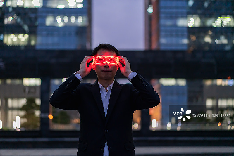 佩戴智能眼镜体验增强现实游戏的亚洲男士图片素材