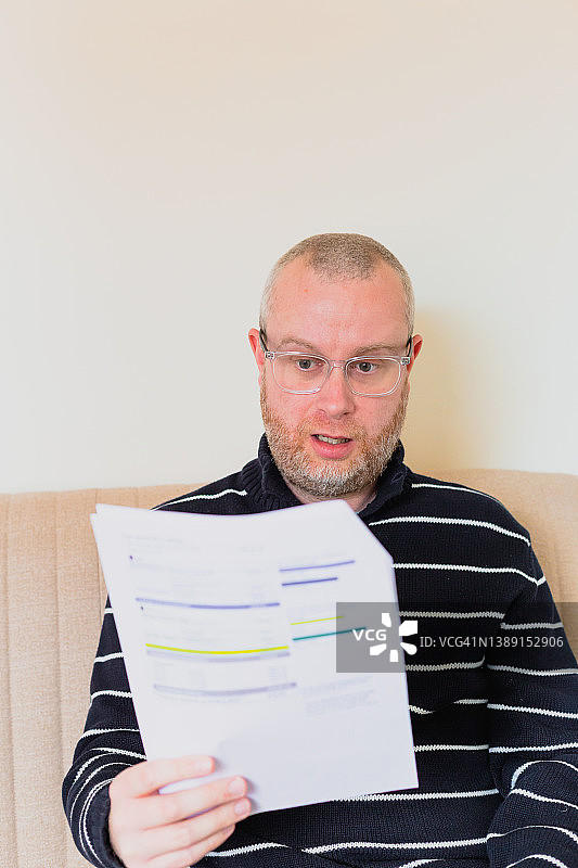 忧虑的男人在家查看账单图片素材