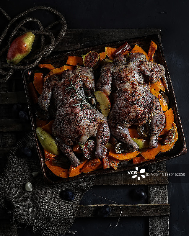 预备烘烤的带香料、水果和蔬菜的未烹饪小鸡，深色乡村背景特写，选择性聚焦图片素材