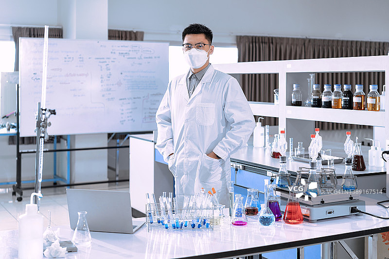 在实验室工作的亚洲青年男科学家肖像（新冠病毒疫情概念）图片素材