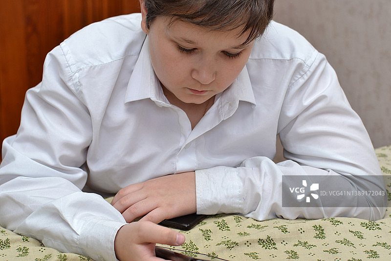 使用智能手机的青少年男孩肖像图片素材