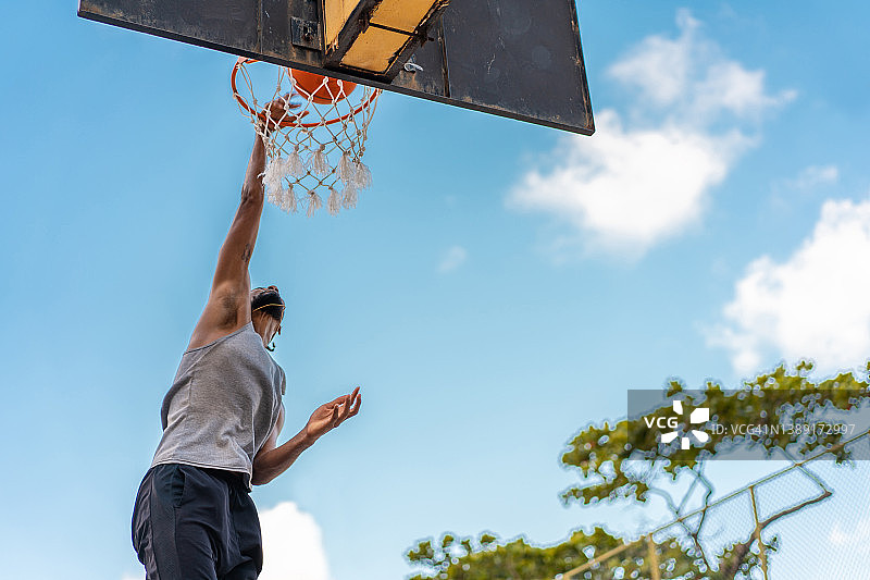 篮球运动员悬挂在篮球框上图片素材