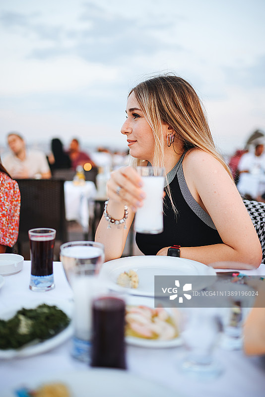 年轻女人喝土耳其茴香酒图片素材